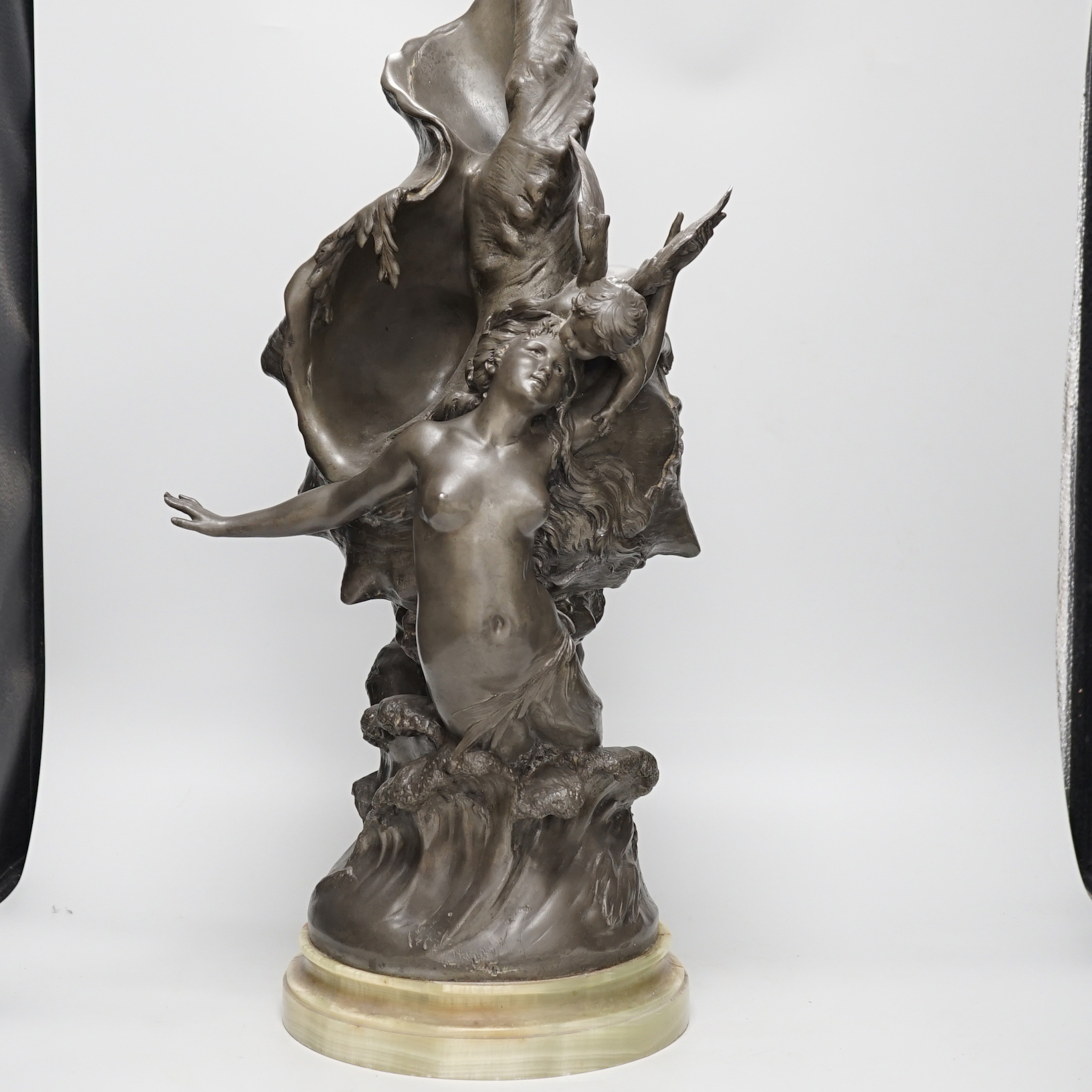 After H. Francois Moreau, a large spelter group of Cupid and a mermaid before a giant conch shell, signed, 64cm high